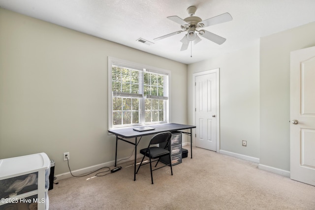 office space with visible vents, baseboards, ceiling fan, and light colored carpet