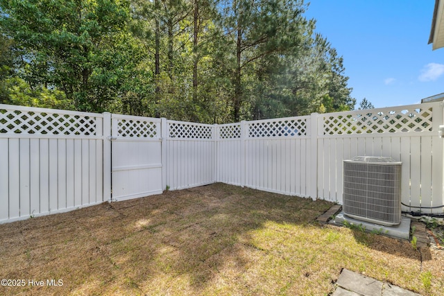 view of yard featuring a fenced backyard and central AC