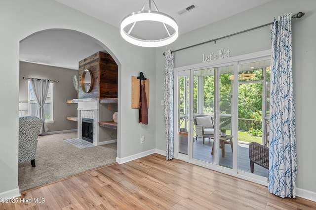 dining area featuring baseboards, a fireplace, wood finished floors, and visible vents