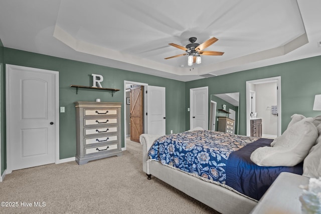bedroom featuring visible vents, a raised ceiling, baseboards, connected bathroom, and carpet flooring