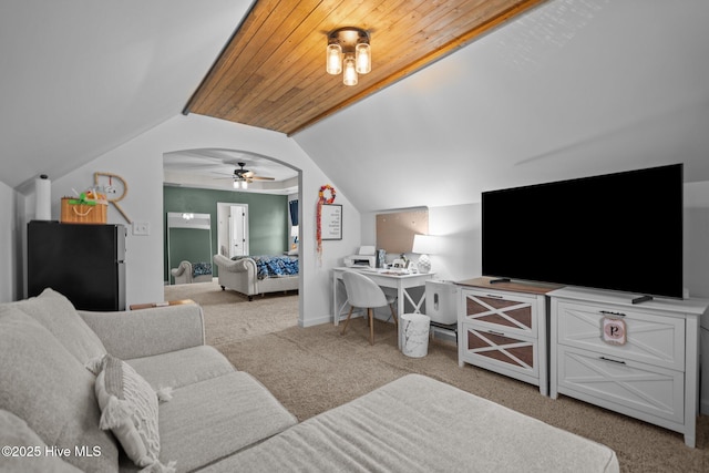 living room featuring carpet, ceiling fan, and vaulted ceiling