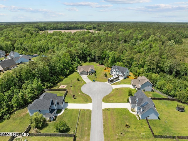 drone / aerial view featuring a residential view and a forest view