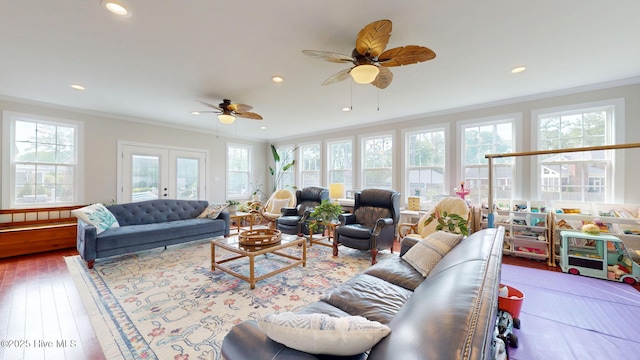 living room featuring recessed lighting, ornamental molding, a wealth of natural light, and hardwood / wood-style flooring