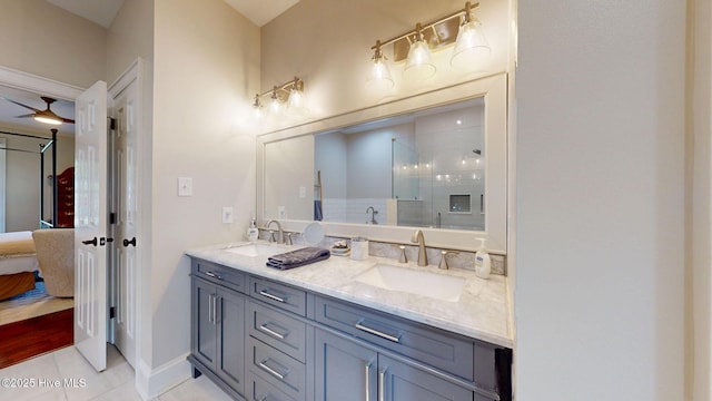 bathroom featuring double vanity, a sink, tile patterned floors, and a tile shower