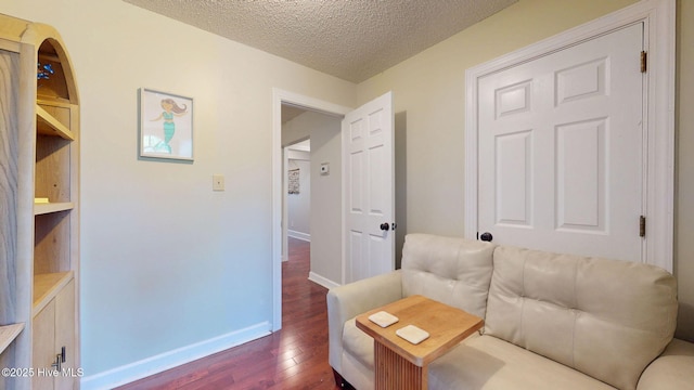 interior space with baseboards, a textured ceiling, and dark wood finished floors