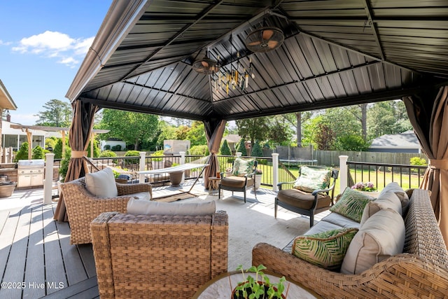 deck with a gazebo, a trampoline, fence, and an outdoor hangout area