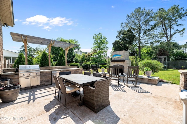view of patio / terrace featuring fence, a pergola, exterior kitchen, an outdoor stone fireplace, and outdoor dining area