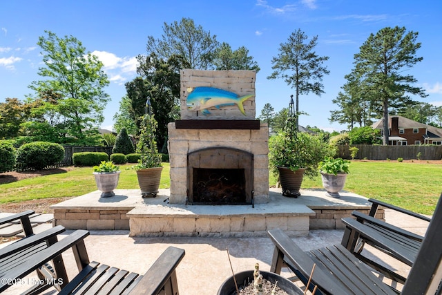 view of patio / terrace with an outdoor stone fireplace and fence