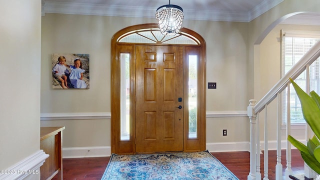 entrance foyer with arched walkways, baseboards, wood finished floors, and a notable chandelier