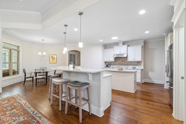kitchen featuring a kitchen island with sink, high end refrigerator, and dark wood-style floors