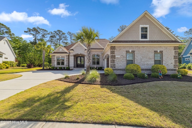 view of front of property with concrete driveway, a front lawn, and brick siding