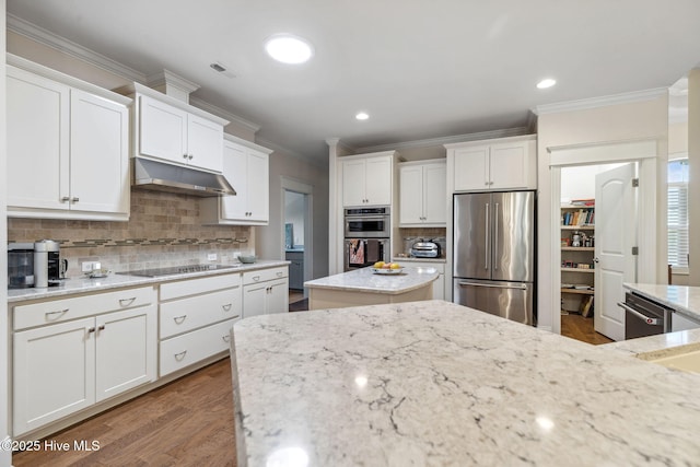 kitchen featuring stainless steel appliances, white cabinets, crown molding, backsplash, and under cabinet range hood