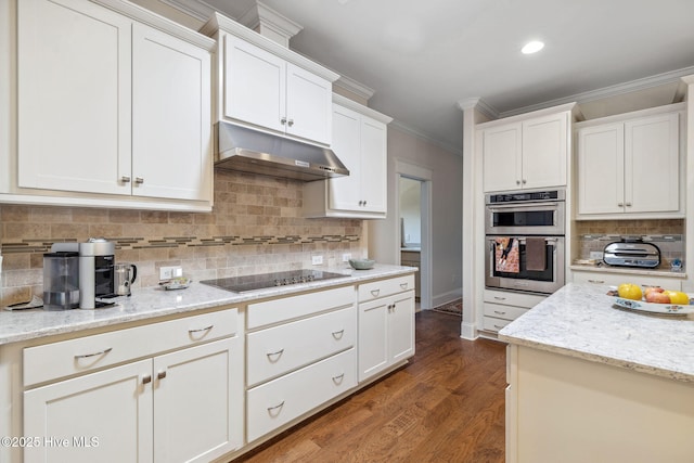 kitchen with under cabinet range hood, ornamental molding, black electric cooktop, double oven, and white cabinets