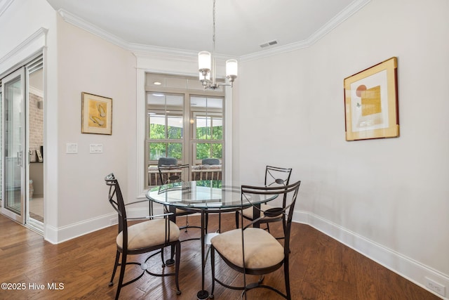 dining room with ornamental molding, visible vents, dark wood-style flooring, a chandelier, and baseboards