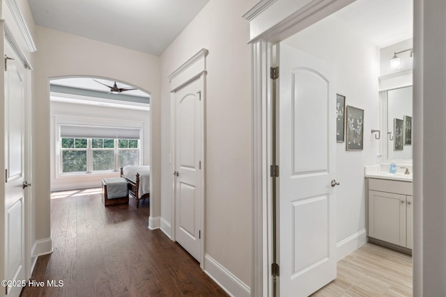 corridor featuring baseboards and wood finished floors