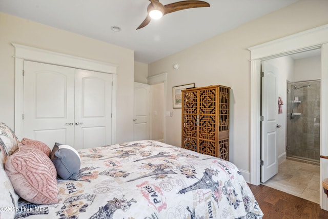 bedroom with a closet, ensuite bath, dark wood-style flooring, and ceiling fan