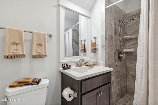 full bathroom featuring vanity, toilet, and a tile shower