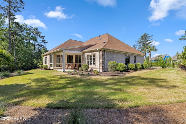 back of house with a yard, brick siding, fence, a patio area, and a shingled roof