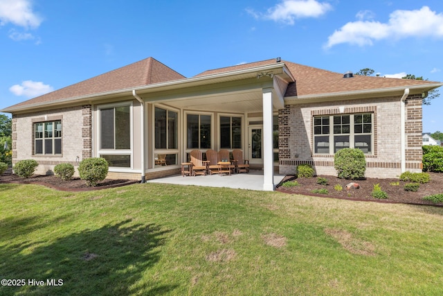 back of property featuring a yard, a patio area, and brick siding