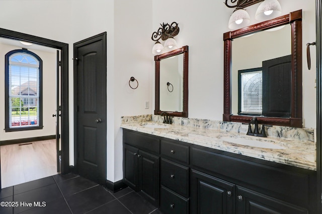 full bathroom featuring double vanity, a sink, and tile patterned flooring