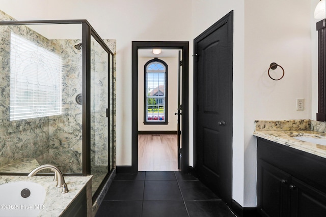 bathroom featuring vanity, a stall shower, a bath, and tile patterned floors