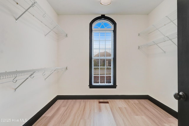 spacious closet featuring wood finished floors and visible vents