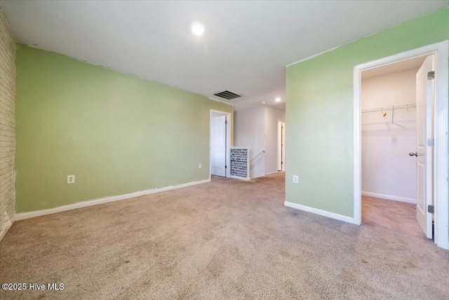 unfurnished bedroom with carpet floors, baseboards, a spacious closet, and visible vents