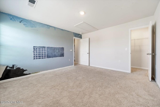 carpeted empty room with visible vents, attic access, and baseboards