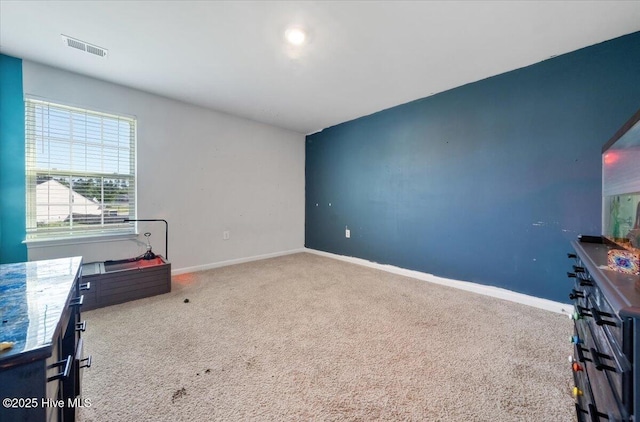 unfurnished bedroom with carpet floors, baseboards, and visible vents