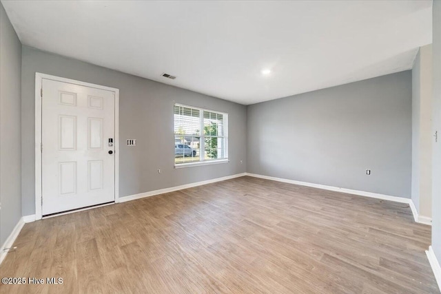 interior space featuring visible vents, light wood-style floors, and baseboards