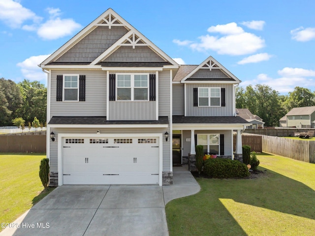 craftsman-style house featuring fence, driveway, stone siding, and a front lawn