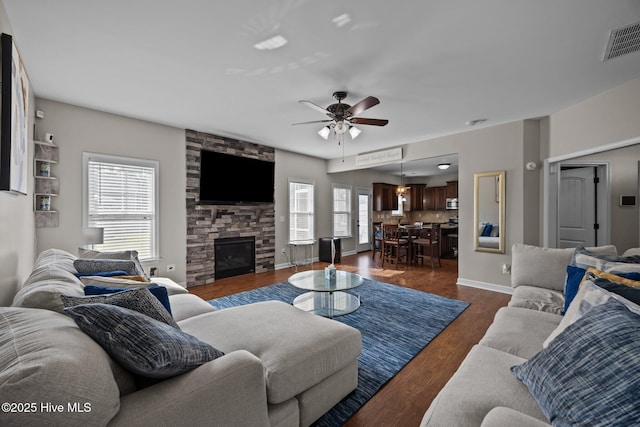 220 Rustic Field Dr, Goldsboro, NC 27530 - living room featuring plenty of natural light, a stone fireplace, ceiling fan, and dark wood-type flooring