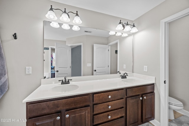 bathroom featuring a sink, toilet, double vanity, and visible vents