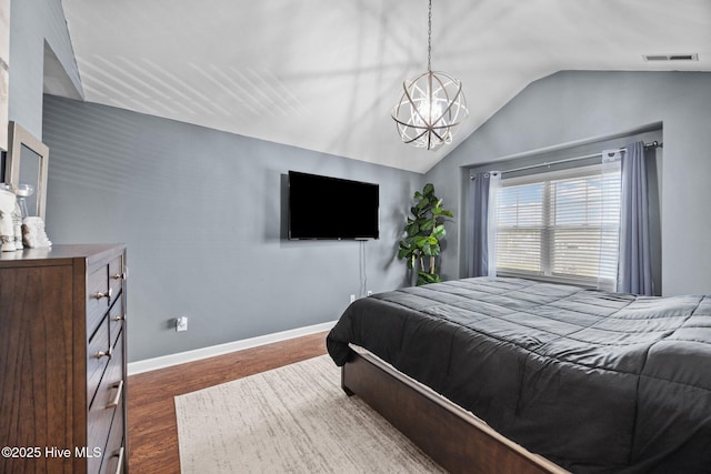 220 Rustic Field Dr, Goldsboro, NC 27530 - bedroom with lofted ceiling, dark wood-style floors, a chandelier, and baseboards
