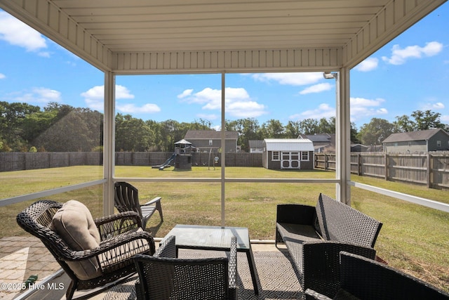 view of patio / terrace featuring a storage shed, an outbuilding, a fenced backyard, and a playground