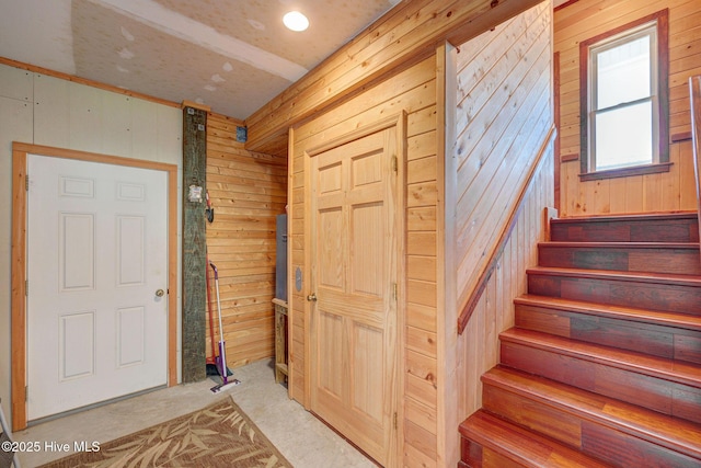 staircase featuring wooden walls