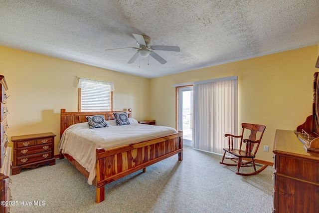 carpeted bedroom featuring multiple windows, a textured ceiling, a ceiling fan, and baseboards