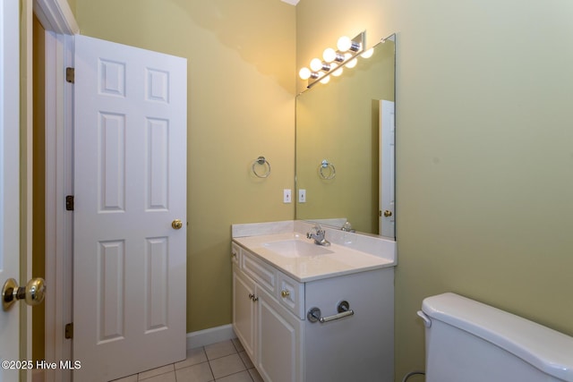 half bathroom with tile patterned floors, vanity, and toilet