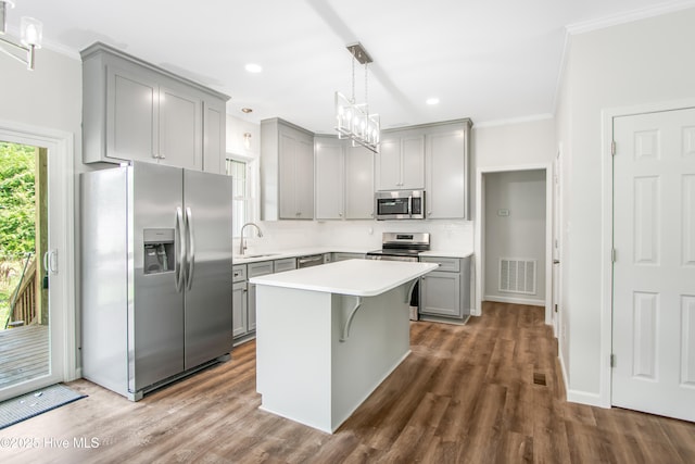 401 Singletary St SE, Wilson, NC 27893 - kitchen featuring appliances with stainless steel finishes, gray cabinets, crown molding, a sink, and light countertops