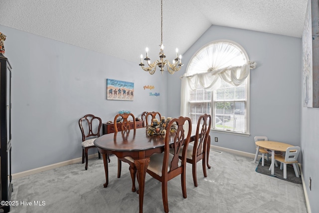 dining space with light colored carpet, a textured ceiling, a chandelier, baseboards, and vaulted ceiling