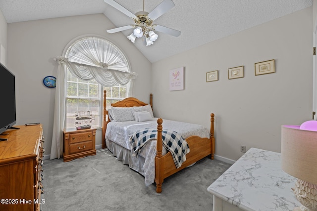 bedroom with a ceiling fan, a textured ceiling, vaulted ceiling, baseboards, and light carpet