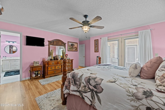 bedroom with ceiling fan, ensuite bath, a textured ceiling, light wood-style flooring, and ornamental molding