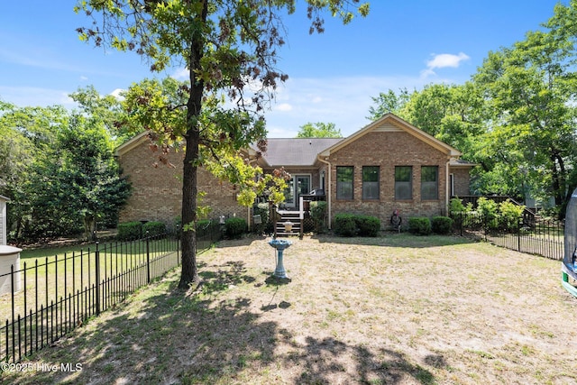 view of front of property featuring brick siding, fence, and a front yard