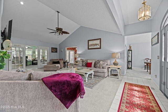 living area with light tile patterned flooring, baseboards, high vaulted ceiling, light colored carpet, and ceiling fan with notable chandelier