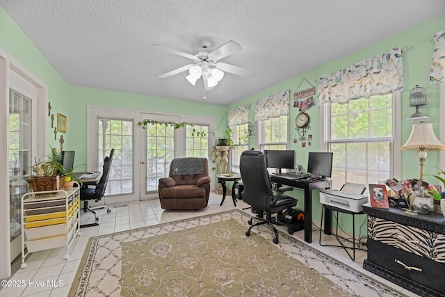 home office with a ceiling fan, a textured ceiling, tile patterned floors, and a healthy amount of sunlight