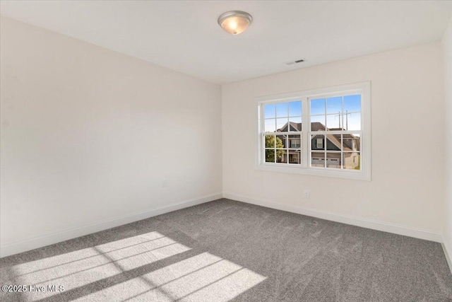 spare room with baseboards, carpet, and visible vents