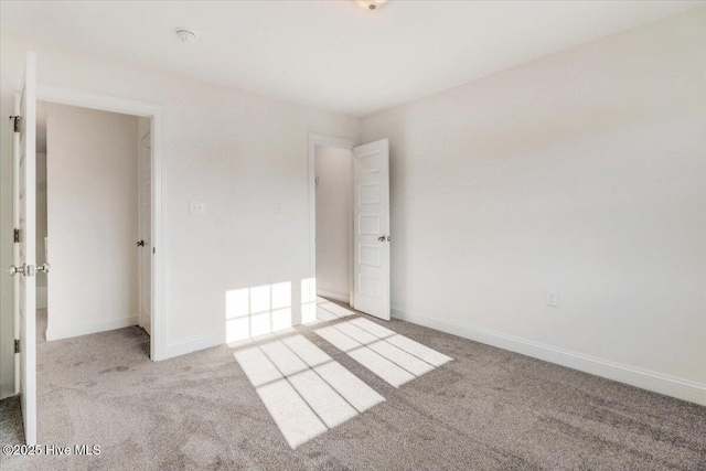 unfurnished bedroom featuring carpet floors and baseboards