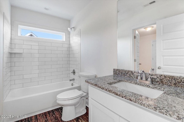 bathroom with visible vents, vanity, wood finished floors, toilet, and washtub / shower combination