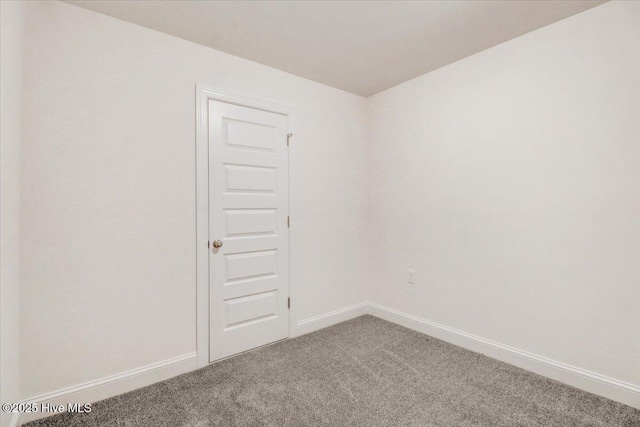 unfurnished room with baseboards and carpet