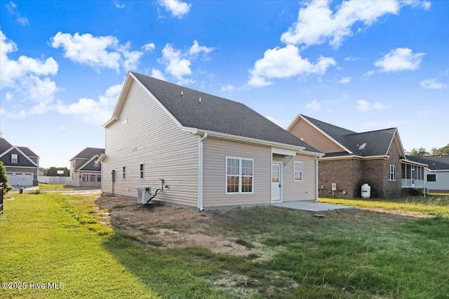 back of property with central air condition unit, a patio, and a yard